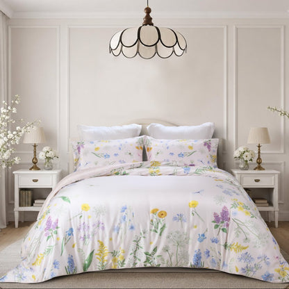 A beautifully styled bedroom featuring a floral print bedding set with a duvet cover and matching pillow shams. The bedding has a delicate pattern of yellow, purple, blue, and green wildflowers on a soft white background.